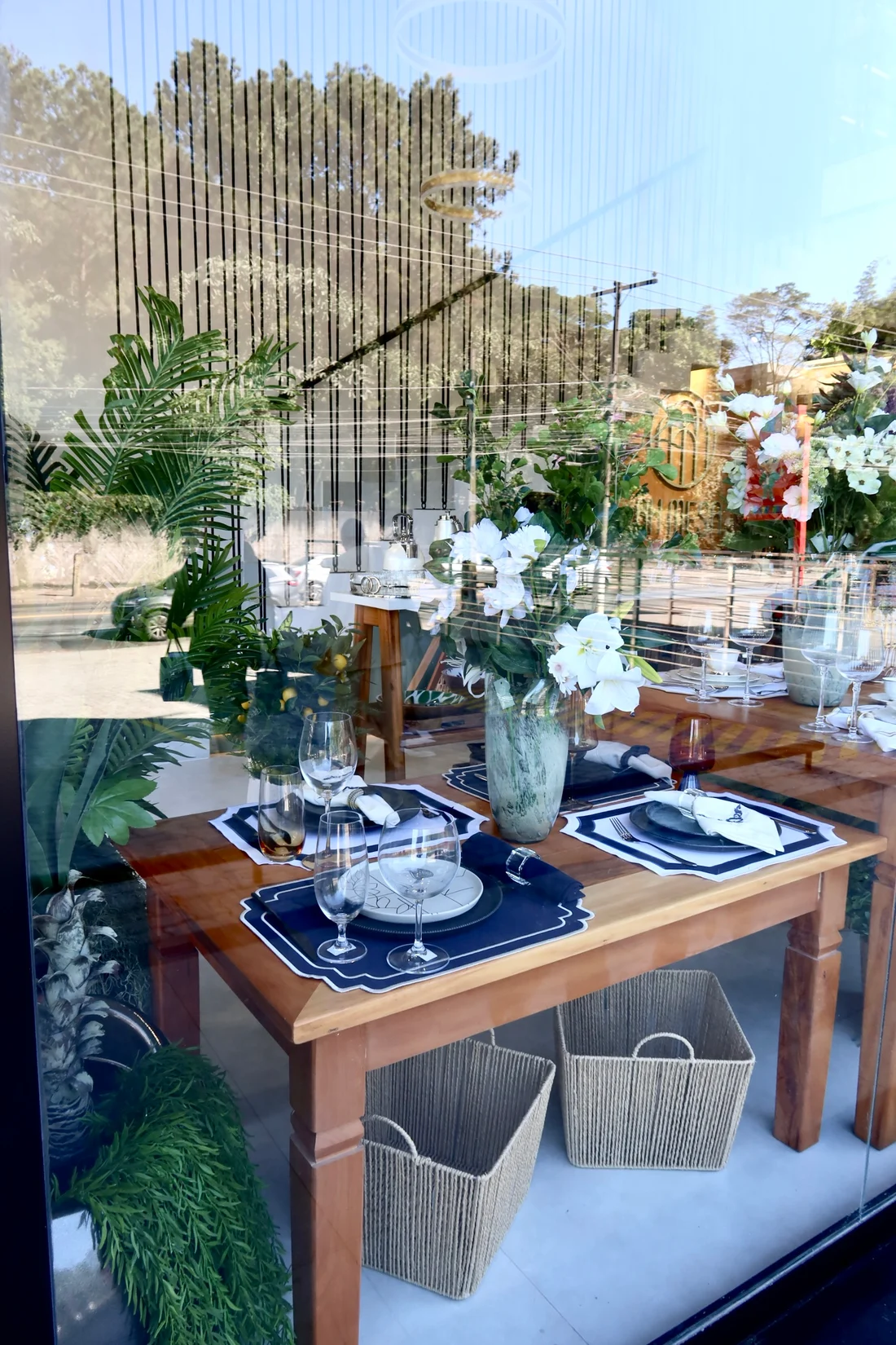 Mesa posta na vitrine AH Mesa, com detalhes em azul